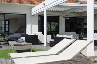 a patio with white furniture and a table at Rooftop grande terrasse jacuzzi vue mer in Cannes