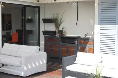 a living room with two white couches and a kitchen at Rooftop grande terrasse jacuzzi vue mer in Cannes