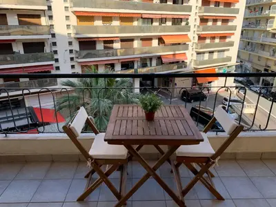 a table and chairs on a balcony with a view of a city at PASTEUR in Cannes