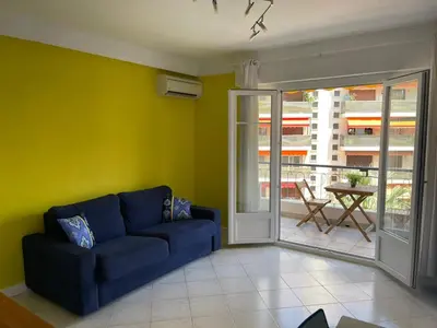 a living room with a blue couch and a patio at PASTEUR in Cannes