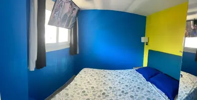 a blue and yellow bedroom with a bed and a window at PASTEUR in Cannes