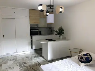a kitchen with white cabinets and a counter top at Studio contemporain à Cannes avec terrasse et parking - 35 m² in Cannes