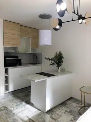 a kitchen with white cabinets and a white counter top at Studio contemporain à Cannes avec terrasse et parking - 35 m² in Cannes