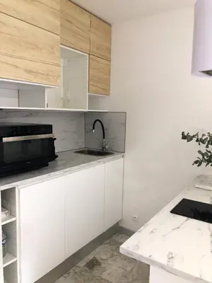 a kitchen with white cabinets and a sink at Studio contemporain à Cannes avec terrasse et parking - 35 m² in Cannes