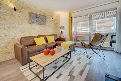 a living room with a couch and a table at IMMOGROOM - Renovated -Parking - AC - Terraces in Cannes