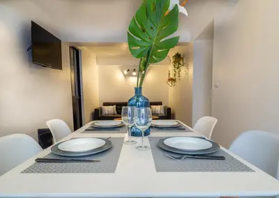 a dining room table with a vase with a plant at Appartement centre de Cannes in Cannes