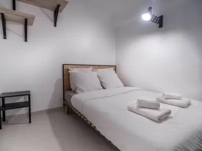 a bedroom with a bed with white sheets and towels at Appartement centre de Cannes in Cannes