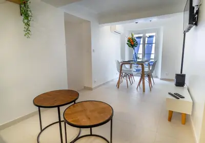 a living room with two stools and a table at Appartement centre de Cannes in Cannes