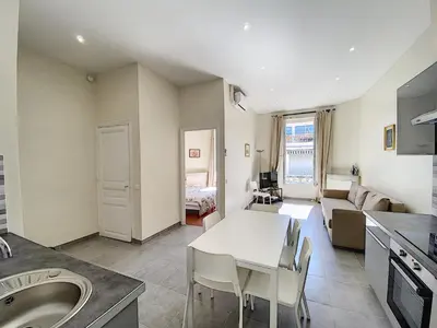 a kitchen and living room with a table and a couch at Lecerf 2P ZEI5517 in Cannes