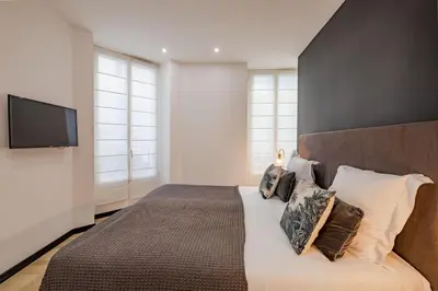 a bedroom with a large bed with a flat screen tv at Scandinavian Urban 1 - 2BR apartment in center close to Palais des Festivals and the beach in Cannes