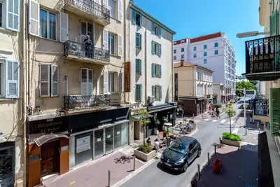 a car driving down a city street with buildings at Scandinavian Urban 1 - 2BR apartment in center close to Palais des Festivals and the beach in Cannes
