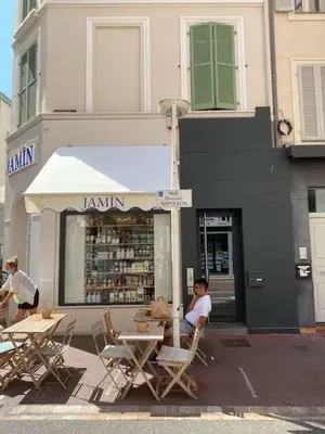 a woman sitting at a table in front of a store at Scandinavian Urban 1 - 2BR apartment in center close to Palais des Festivals and the beach in Cannes