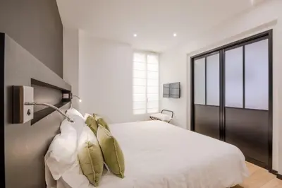 a bedroom with a bed with white sheets and pillows at Scandinavian Urban 1 - 2BR apartment in center close to Palais des Festivals and the beach in Cannes