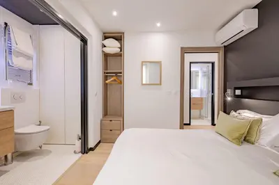a bedroom with a large white bed and a bathroom at Scandinavian Urban 1 - 2BR apartment in center close to Palais des Festivals and the beach in Cannes