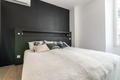 a bedroom with a large bed with a black headboard at Scandinavian Urban 2 - 2BR apartment in center close to Palais des Festivals and the beach in Cannes