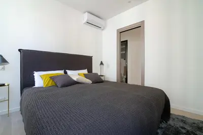a bedroom with a large bed with yellow and gray pillows at Scandinavian Urban 2 - 2BR apartment in center close to Palais des Festivals and the beach in Cannes