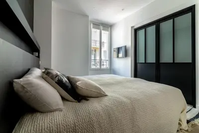 a bedroom with a bed with pillows and a window at Scandinavian Urban 2 - 2BR apartment in center close to Palais des Festivals and the beach in Cannes