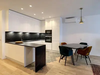 a kitchen with a table and a table and chairs at Luxe et Confort - Proche Palais et plages - A/C in Cannes
