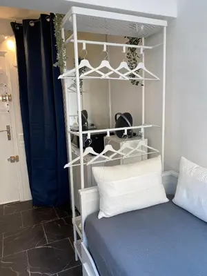 a room with a bed and a shelf with hats at STUDIO 45 CROISETTE CANNES in Cannes