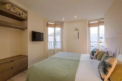 a bedroom with a bed with a tv on the wall at Scandinavian Urban 3 - 2BR apartment in Cannes center - close to the beach and Palais in Cannes