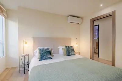a bedroom with a large bed with blue pillows at Scandinavian Urban 3 - 2BR apartment in Cannes center - close to the beach and Palais in Cannes