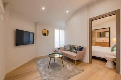 a living room with a couch and a tv and a bed at Scandinavian Urban 4 - 1BR apartment in Cannes center close to the beach and the Palais in Cannes