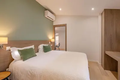 a bedroom with a white bed with two green pillows at Scandinavian Urban 4 - 1BR apartment in Cannes center close to the beach and the Palais in Cannes