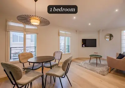 a living room with a table and chairs and a tv at Scandinavian Urban 4 - 1BR apartment in Cannes center close to the beach and the Palais in Cannes