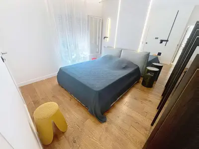 a bedroom with a bed and a yellow stool at Fantastic penthouse 3 bedroom Croisette 406 in Cannes