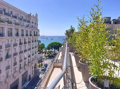 a balcony with plants in large pots next to a building at Fantastic penthouse 3 bedroom Croisette 406 in Cannes