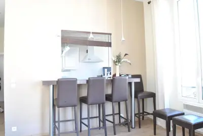 a kitchen with a table with chairs and a mirror at Lecerf 2P CUR1095 in Cannes