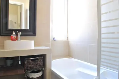 a bathroom with a sink and a tub and a mirror at Lecerf 2P CUR1095 in Cannes