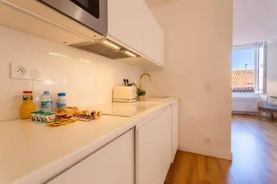 a kitchen with white cabinets and a counter top at Marechal Foch / GOLD2025 / ST in Cannes