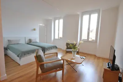 a bedroom with a bed and a table with a chair at Marechal Foch / GOLD2025 / ST in Cannes