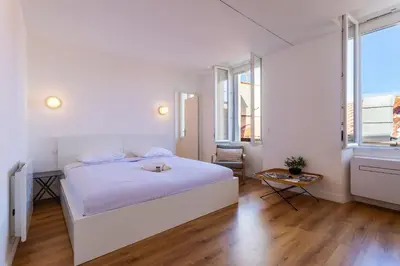 a white bedroom with a white bed and windows at Marechal Foch / GOLD2025 / ST in Cannes