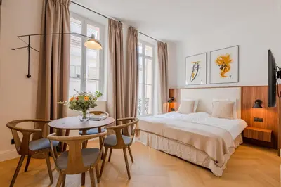 a hotel room with a bed and a table at La Guitare 21 - Cozy studio in center of Cannes, just behind Grand Hotel in Cannes