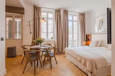 a bedroom with a bed and a table and chairs at La Guitare 21 - Cozy studio in center of Cannes, just behind Grand Hotel in Cannes
