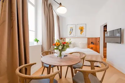 a hotel room with a table and chairs and a bed at La Guitare 21 - Cozy studio in center of Cannes, just behind Grand Hotel in Cannes