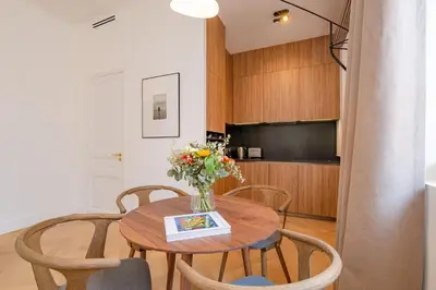 a dining room table with a vase of flowers on it at La Guitare 21 - Cozy studio in center of Cannes, just behind Grand Hotel in Cannes