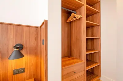 a closet with wooden doors and a lamp at La Guitare 21 - Cozy studio in center of Cannes, just behind Grand Hotel in Cannes