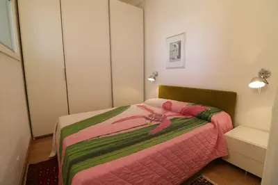 a bedroom with a bed with a pink flower on it at 1 bedroom Suquet, 6 min from the Palais, balcony city & port view 220 in Cannes