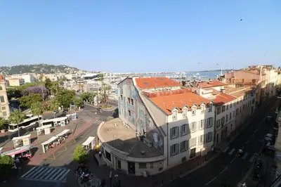 a building with an orange roof on a city street at 1 bedroom Suquet, 6 min from the Palais, balcony city & port view 220 in Cannes