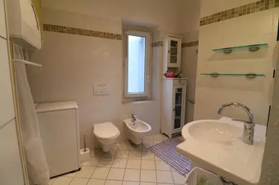a white bathroom with a toilet and a sink at 1 bedroom Suquet, 6 min from the Palais, balcony city & port view 220 in Cannes