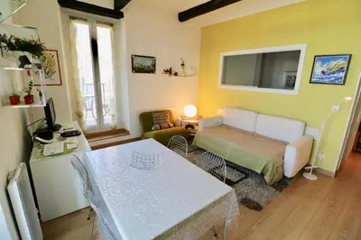 a bedroom with a bed and a table in a room at 1 bedroom Suquet, 6 min from the Palais, balcony city & port view 220 in Cannes
