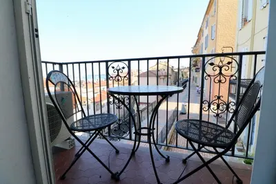 a balcony with a table and chairs on a balcony at 1 bedroom Suquet, 6 min from the Palais, balcony city & port view 220 in Cannes