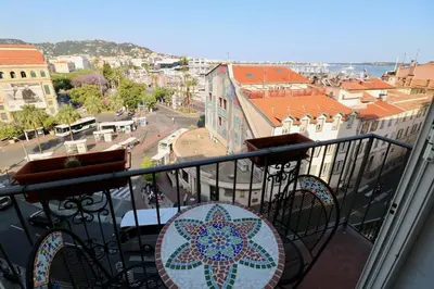 a balcony with a table and a view of a city at 1 bedroom Suquet, 6 min from the Palais, balcony city & port view 220 in Cannes