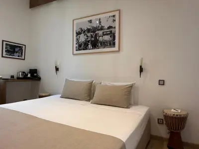 a white bed in a room with a picture on the wall at Ideal Sejour Cannes - Hôtel de Charme in Cannes
