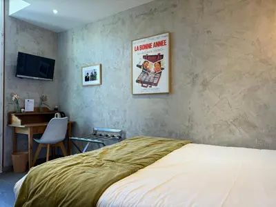 a bedroom with a bed and a desk and a television at Ideal Sejour Cannes - Hôtel de Charme in Cannes