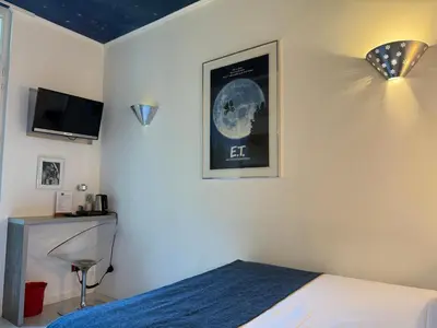 a bedroom with a bed and a picture of the moon at Ideal Sejour Cannes - Hôtel de Charme in Cannes