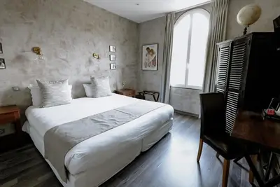 a bedroom with a large white bed and a desk at Ideal Sejour Cannes - Hôtel de Charme in Cannes